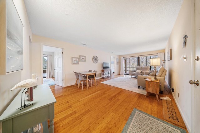 living room featuring hardwood / wood-style flooring, a textured ceiling, and a wealth of natural light