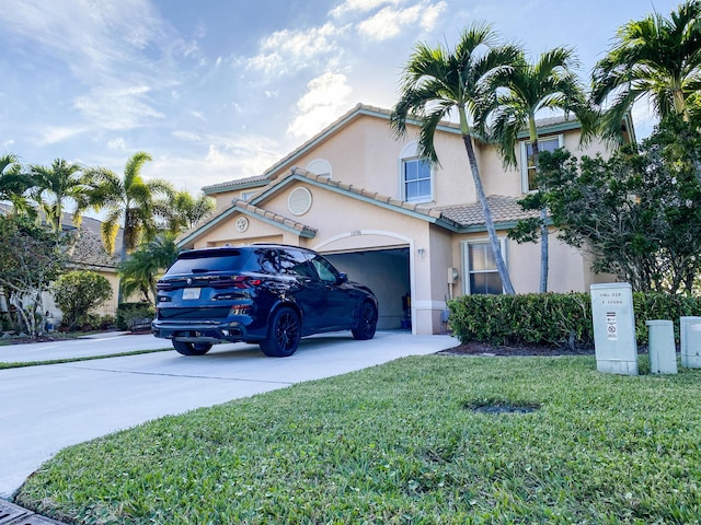 view of front of home with concrete driveway, stucco siding, a tile roof, an attached garage, and a front yard