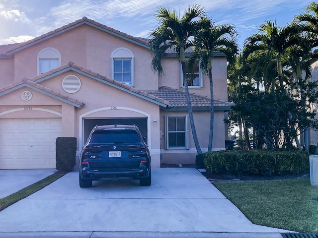 10586 Pelican Dr, Wellington, FL 33414 - mediterranean / spanish-style house with stucco siding, a tile roof, an attached garage, and concrete driveway