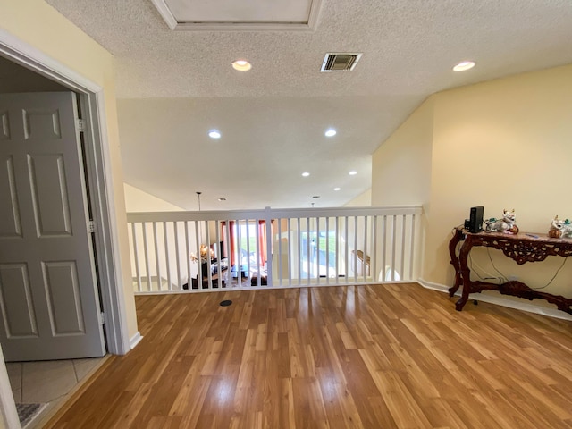 interior space with light wood-style floors, visible vents, a textured ceiling, and recessed lighting