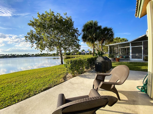 view of patio / terrace with a sunroom, a water view, and grilling area