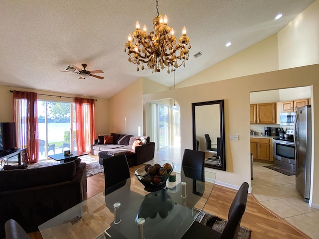 10586 Pelican Dr, Wellington, FL 33414 - dining space with vaulted ceiling, a textured ceiling, ceiling fan with notable chandelier, light wood-style flooring, and visible vents
