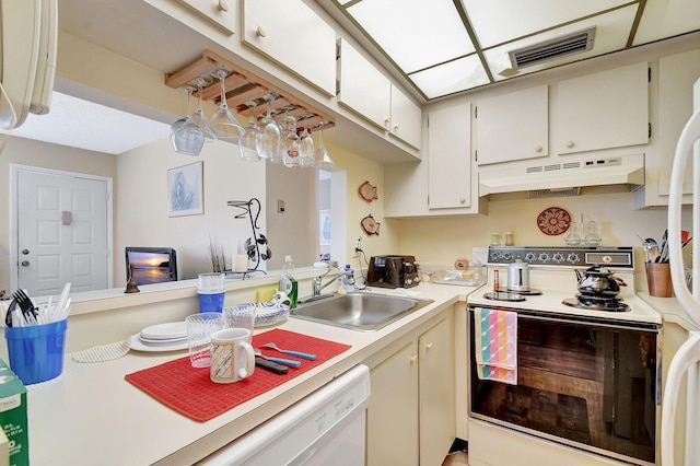 kitchen with pendant lighting, sink, white fridge, and electric range