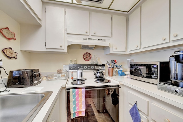 kitchen with electric stove, sink, and white cabinets