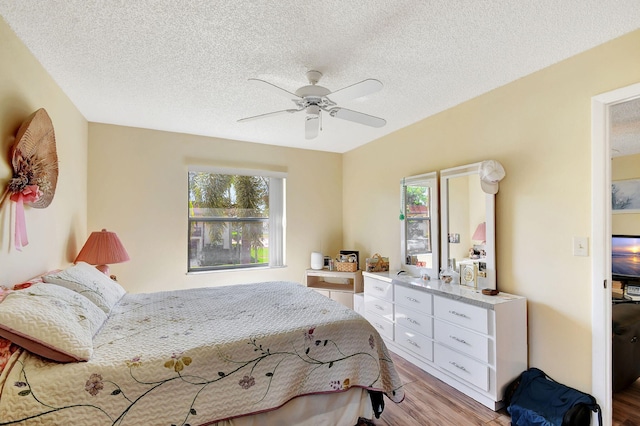 bedroom featuring a textured ceiling, light hardwood / wood-style floors, and ceiling fan