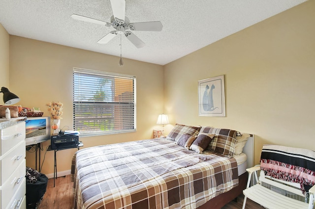 bedroom with ceiling fan, dark hardwood / wood-style floors, and a textured ceiling