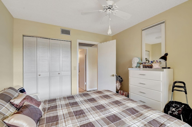 bedroom featuring ceiling fan, a closet, and a textured ceiling