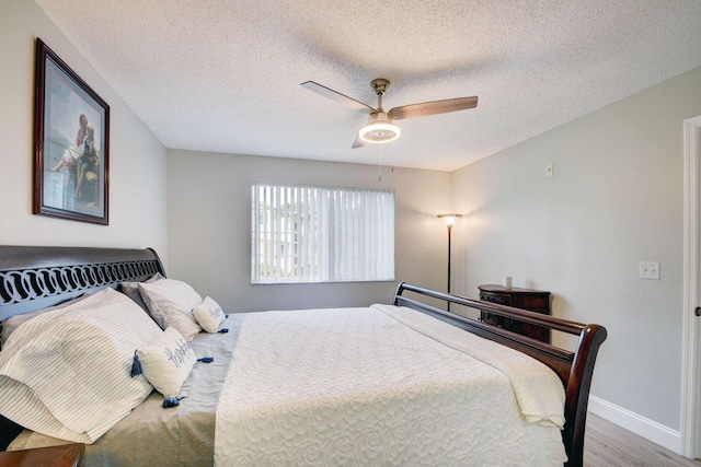 bedroom featuring hardwood / wood-style flooring, a textured ceiling, and ceiling fan