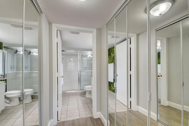 bathroom featuring tile patterned flooring, a bidet, a shower with shower door, and toilet