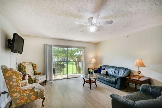 living room with ceiling fan, a textured ceiling, and light hardwood / wood-style flooring