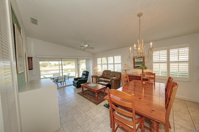 tiled dining space featuring ceiling fan with notable chandelier, vaulted ceiling, and a textured ceiling