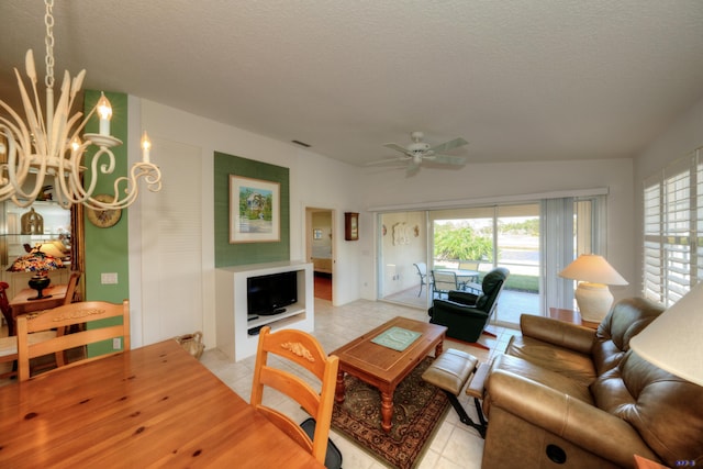 tiled living room with ceiling fan with notable chandelier and a textured ceiling