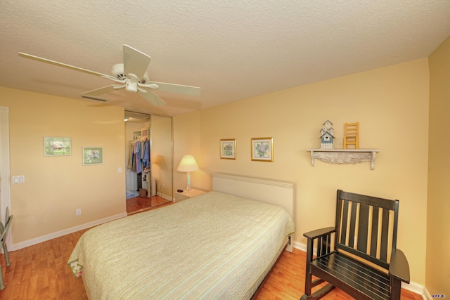 bedroom with ceiling fan, wood-type flooring, a closet, and a textured ceiling