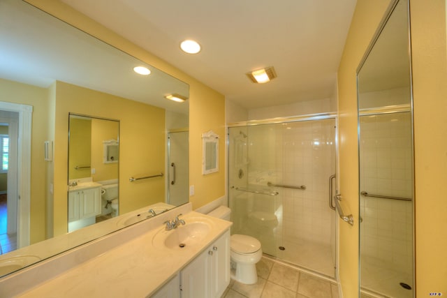 bathroom featuring vanity, toilet, tile patterned flooring, and a shower with door