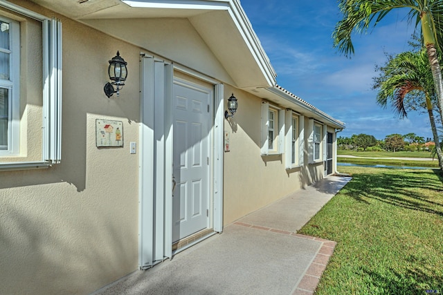 view of exterior entry with a lawn