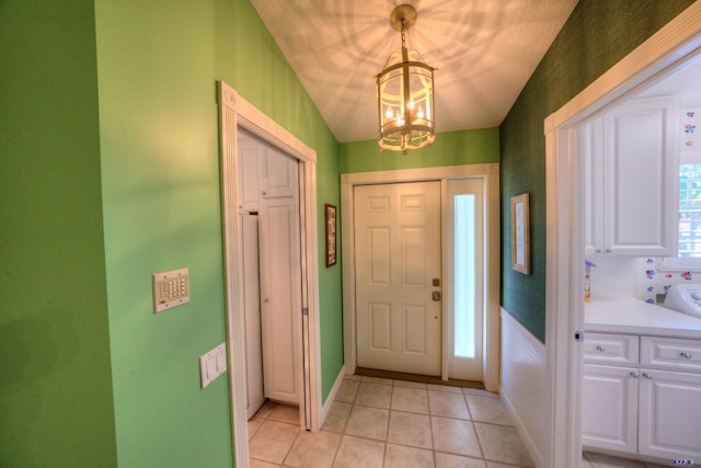 entryway featuring a chandelier and light tile patterned floors