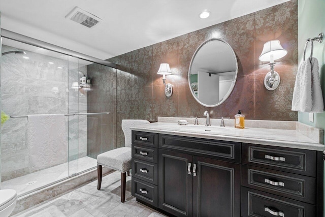 bathroom featuring vanity, toilet, and a shower with shower door