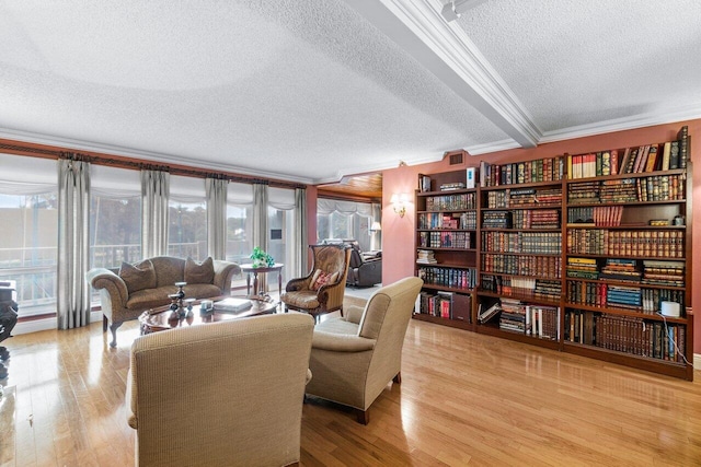 sitting room featuring crown molding, wood-type flooring, and a textured ceiling