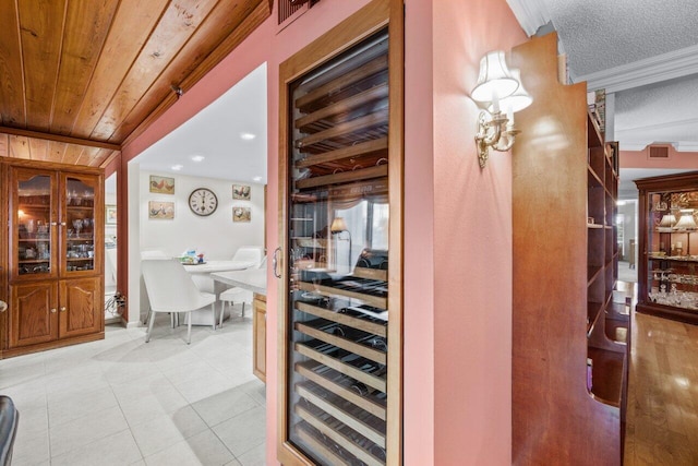 bar featuring crown molding, light tile patterned floors, and wooden ceiling