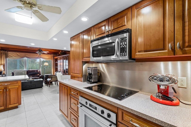 kitchen featuring light tile patterned floors, stainless steel appliances, and ceiling fan