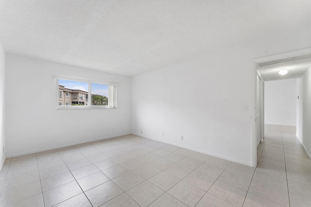 tiled spare room featuring a textured ceiling