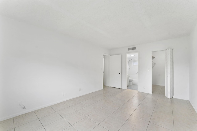 unfurnished room featuring light tile patterned floors and a textured ceiling