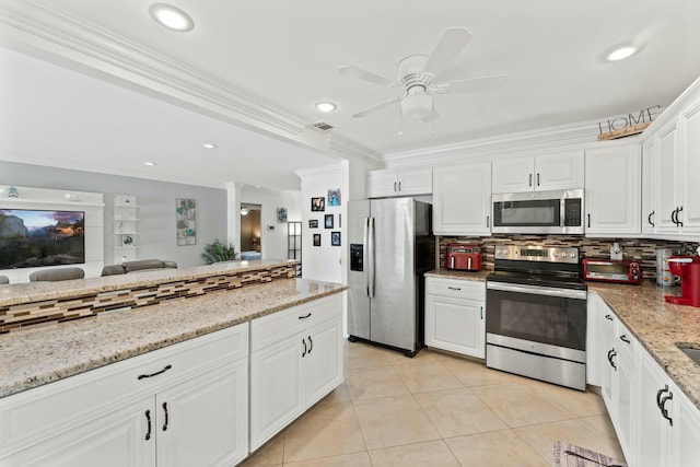 kitchen featuring light tile patterned floors, crown molding, backsplash, stainless steel appliances, and white cabinets