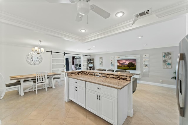 kitchen with white cabinetry, ornamental molding, light stone countertops, stainless steel fridge with ice dispenser, and a barn door