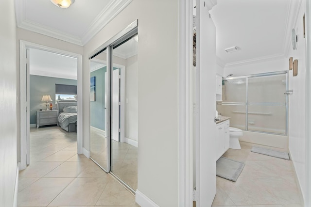 hallway featuring ornamental molding and light tile patterned flooring