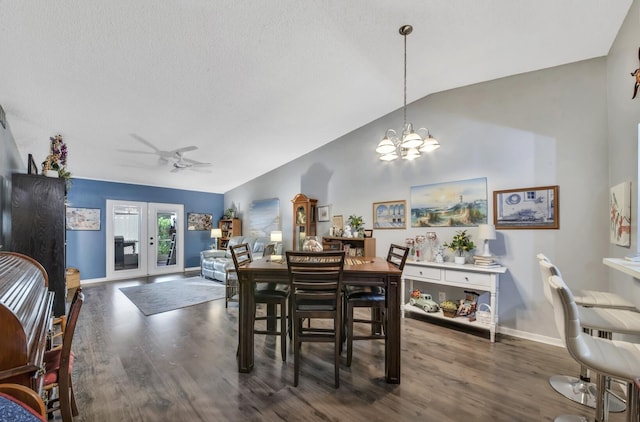 dining space with baseboards, lofted ceiling, dark wood-type flooring, a textured ceiling, and ceiling fan with notable chandelier