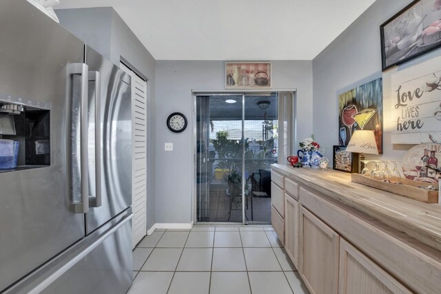 kitchen featuring sink, an inviting chandelier, decorative light fixtures, light tile patterned floors, and stainless steel appliances