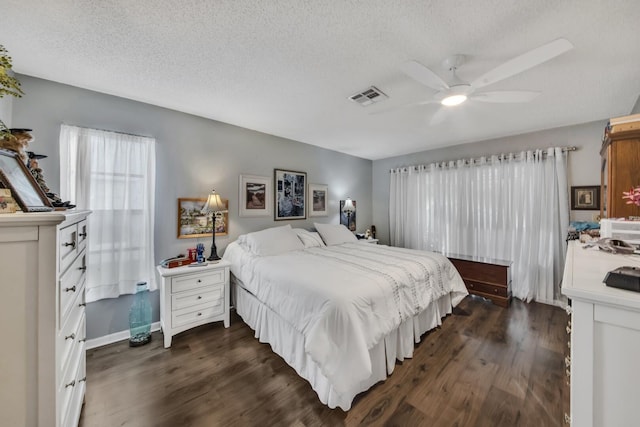 bedroom featuring ceiling fan, dark hardwood / wood-style floors, and a textured ceiling