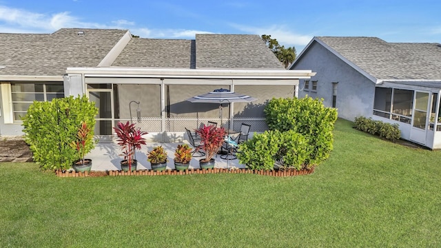 rear view of property featuring a lawn, a sunroom, and a patio area