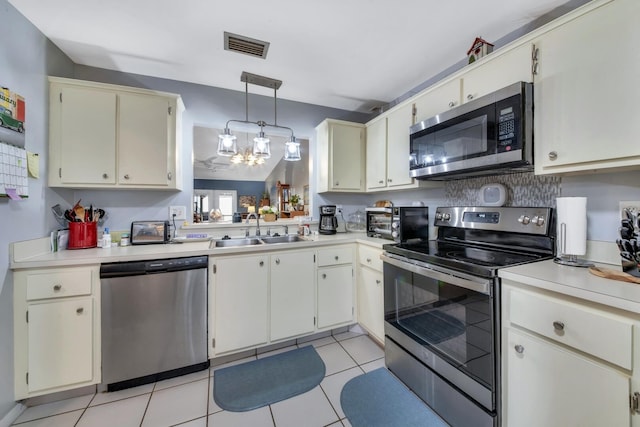 kitchen featuring sink, decorative light fixtures, a chandelier, light tile patterned floors, and appliances with stainless steel finishes