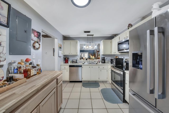 kitchen with pendant lighting, sink, light tile patterned floors, appliances with stainless steel finishes, and electric panel