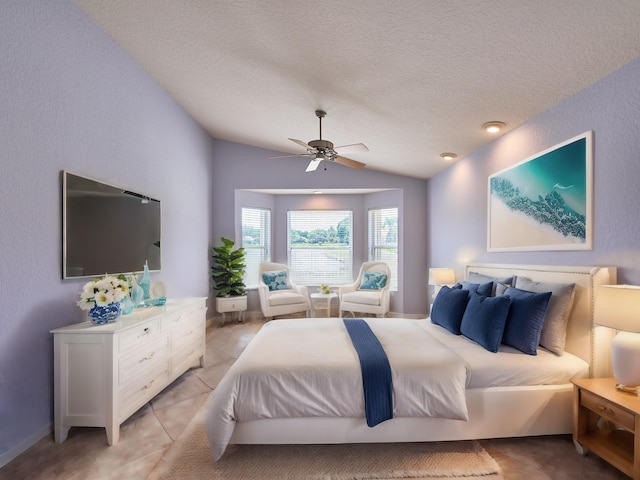 bedroom featuring vaulted ceiling, light tile patterned floors, a textured ceiling, and ceiling fan