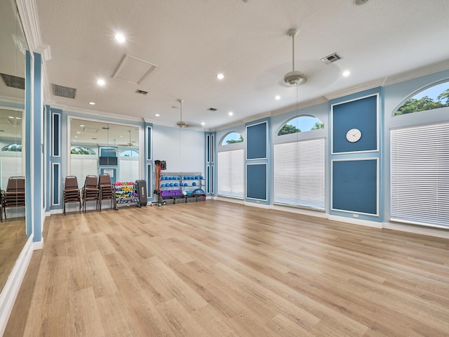 exercise room featuring crown molding, plenty of natural light, and light wood-type flooring