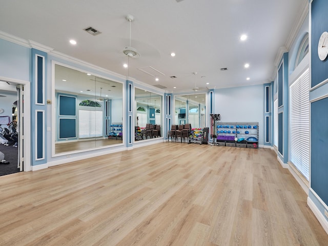 workout room with ornamental molding and light wood-type flooring