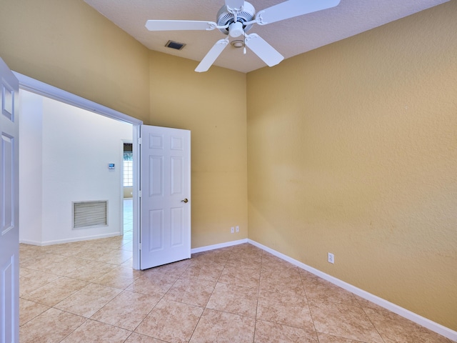 tiled spare room with ceiling fan