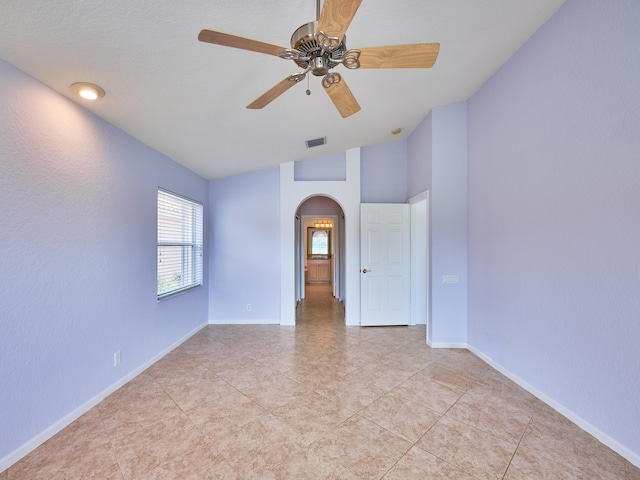 spare room featuring light tile patterned floors, vaulted ceiling, and ceiling fan