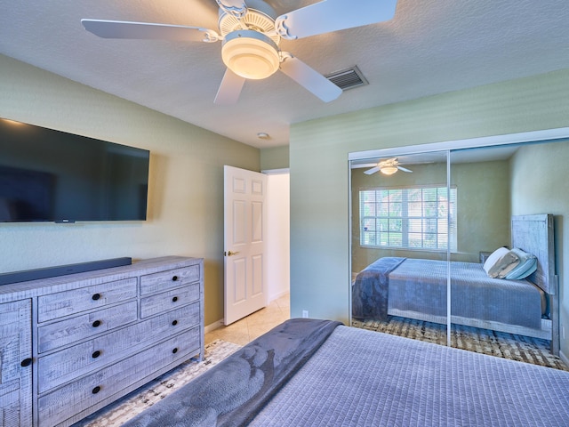 bedroom featuring light tile patterned flooring, ceiling fan, and a closet