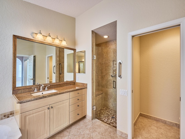 bathroom with tile patterned flooring, vanity, and a shower with shower door