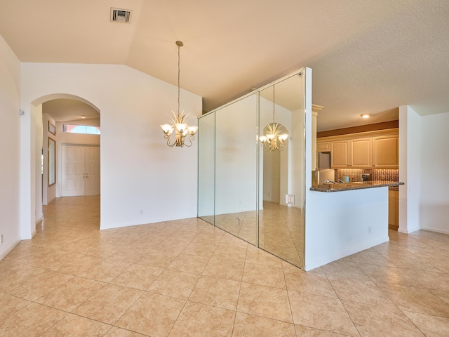 spare room featuring a notable chandelier and light tile patterned floors