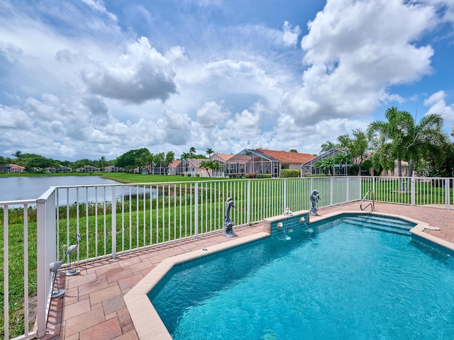 view of pool with a water view and a lawn