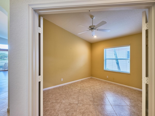 unfurnished room featuring light tile patterned flooring, ceiling fan, plenty of natural light, and a textured ceiling