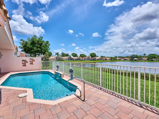 view of pool with a patio area, a lawn, and a water view