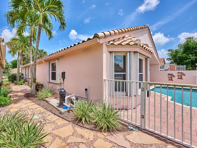 view of side of home featuring a fenced in pool