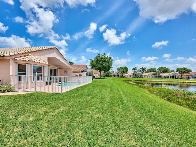 view of yard with a water view, ceiling fan, and a patio