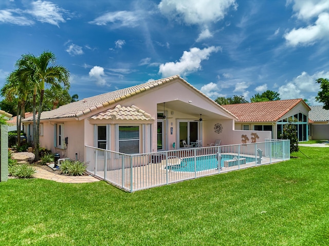 back of property with a lawn, a patio, and ceiling fan