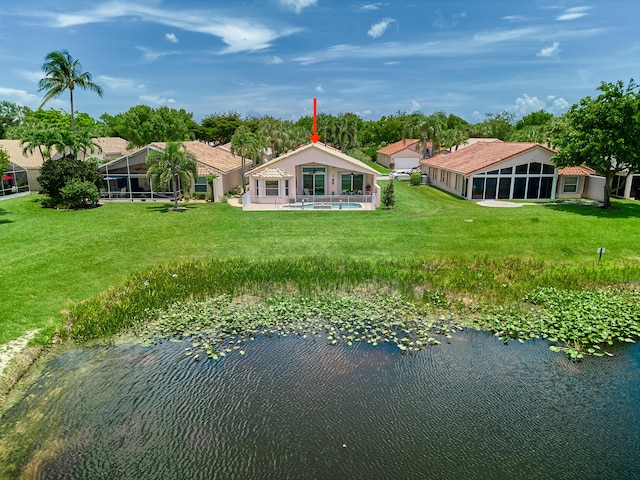 back of property with a water view, a yard, and a sunroom